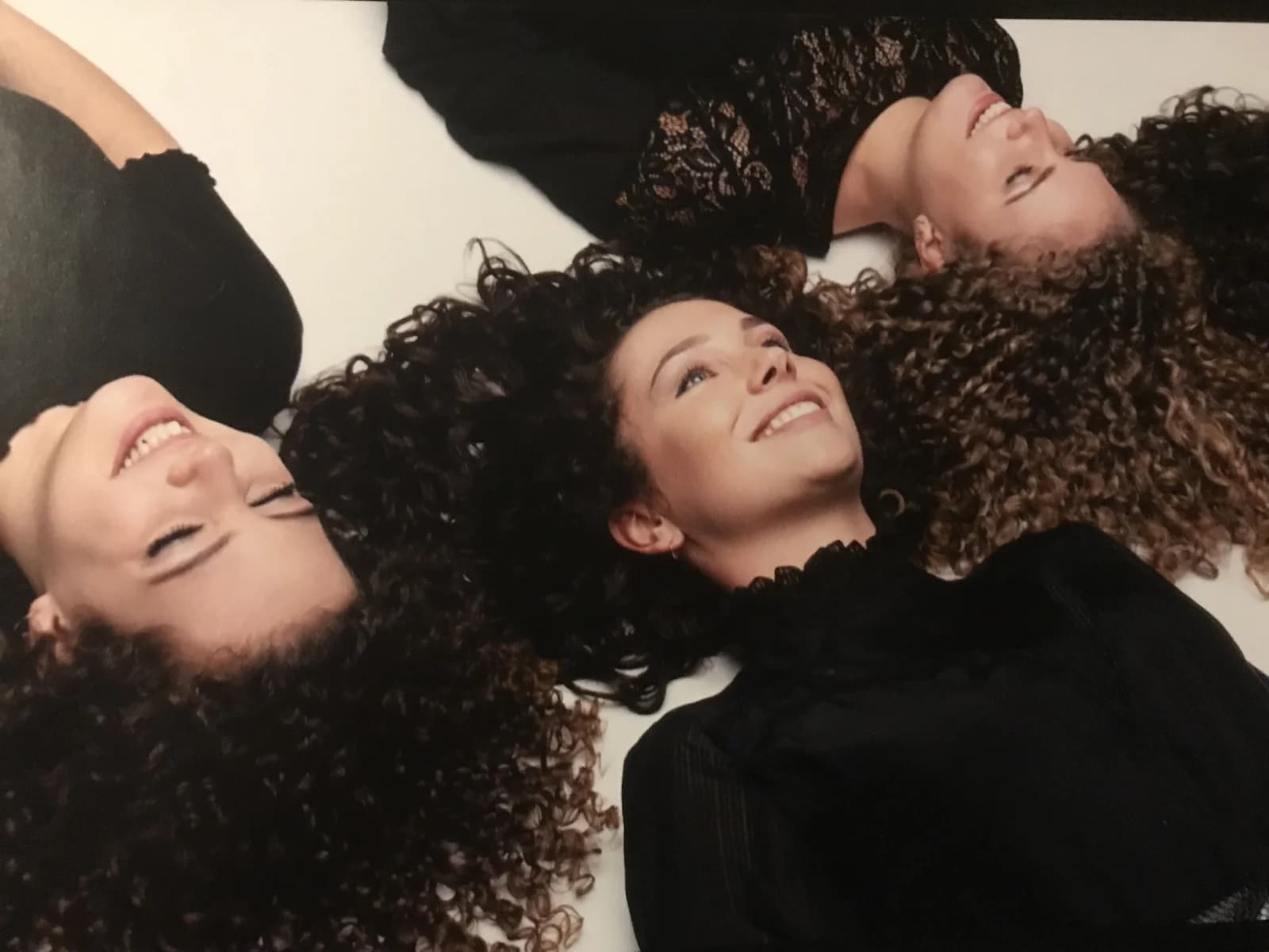 Drie vrouwen met verschillende soorten natuurlijk krullend haar.